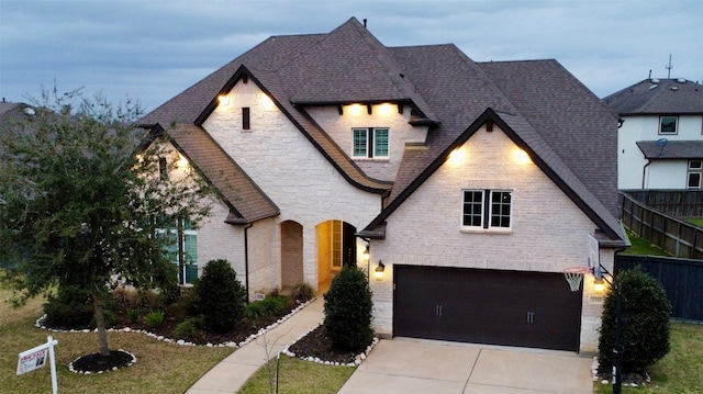 1310 Layla Sage Loop, Richmond, TX 77406 - french country inspired facade with fence, a shingled roof, stone siding, concrete driveway, and an attached garage