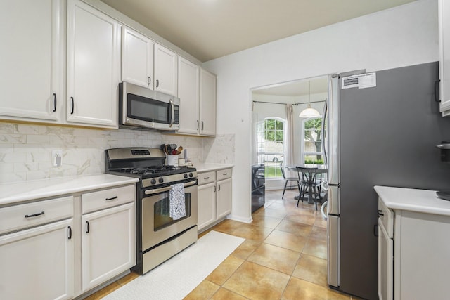 19819 Sloan Ridge Ln, Cypress, TX 77429 - kitchen with appliances with stainless steel finishes, tasteful backsplash, light countertops, light tile patterned floors, and white cabinetry