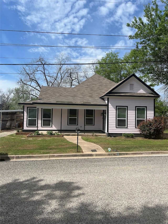 view of front of house with a porch, a shingled roof, and a front lawn