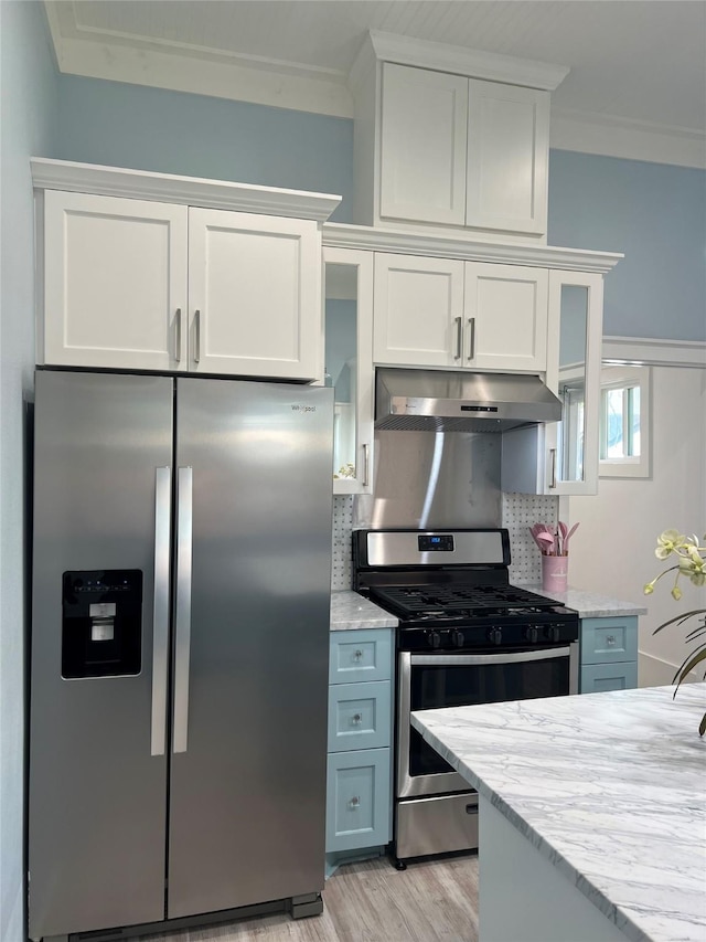kitchen featuring under cabinet range hood, appliances with stainless steel finishes, crown molding, and white cabinetry