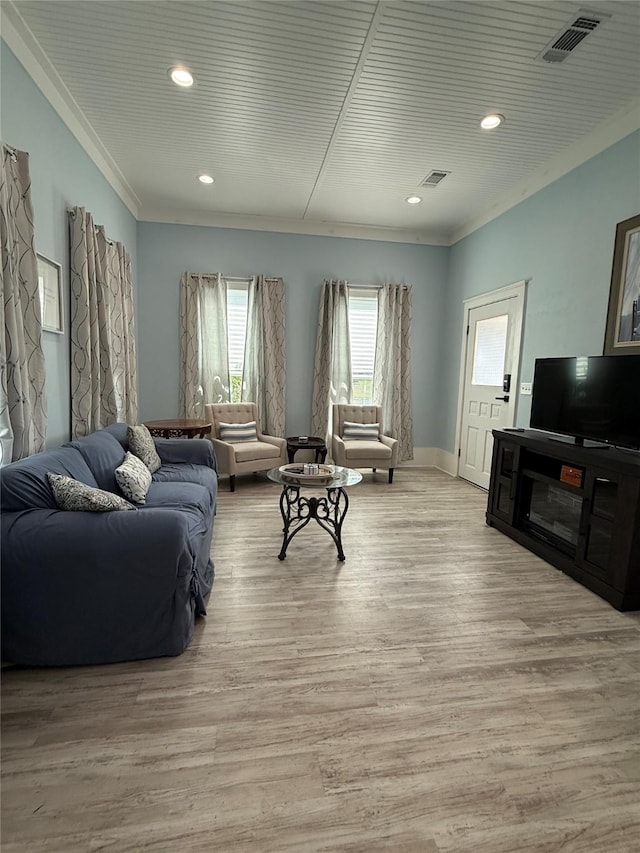 living area featuring recessed lighting, light wood-type flooring, visible vents, and ornamental molding