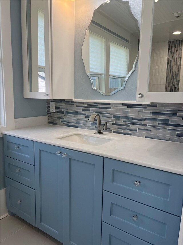 bathroom with backsplash, visible vents, tile patterned flooring, and vanity