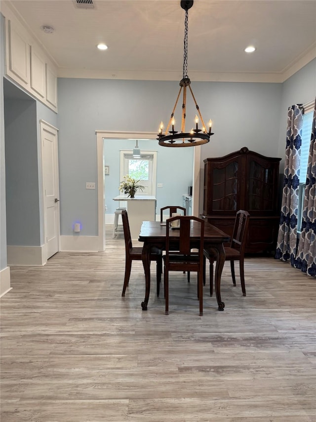 dining area featuring crown molding, an inviting chandelier, light wood finished floors, baseboards, and recessed lighting