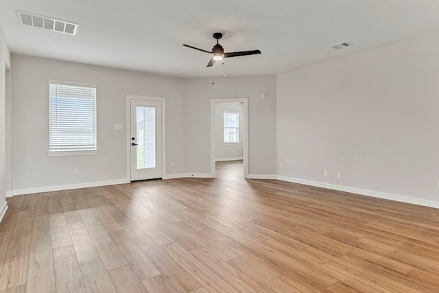unfurnished living room with light wood-style flooring, visible vents, baseboards, and ceiling fan