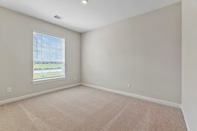 unfurnished room featuring light colored carpet, baseboards, and visible vents