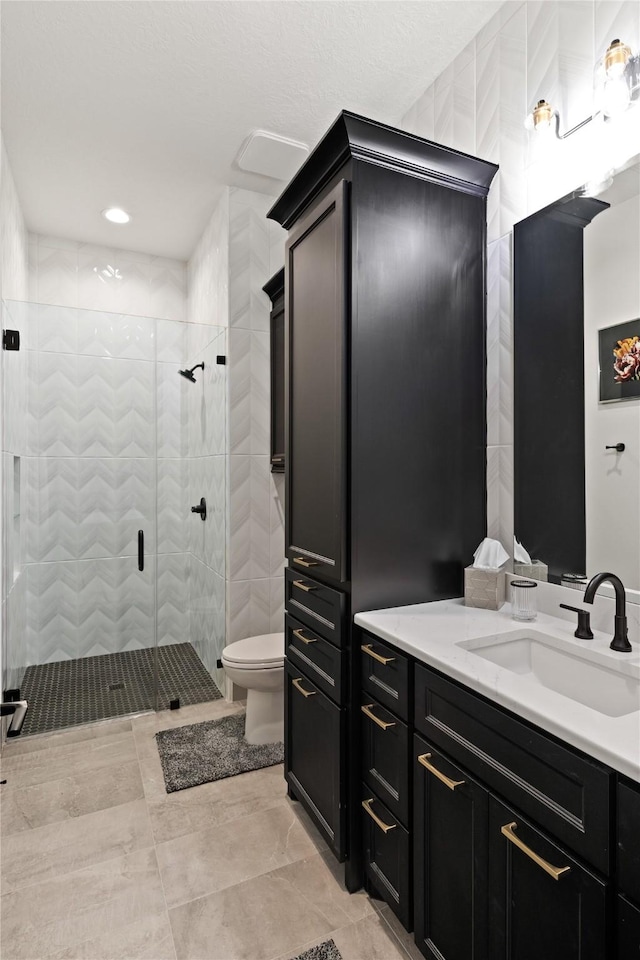 bathroom with vanity, toilet, and a shower stall