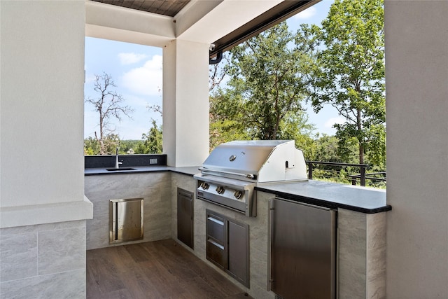 view of patio featuring an outdoor kitchen, a sink, and grilling area