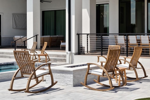 exterior space with a patio, a ceiling fan, and an outdoor fire pit