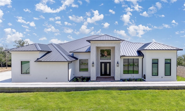 modern farmhouse with a standing seam roof, metal roof, and stucco siding