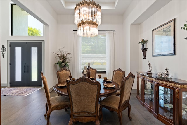 dining space featuring dark wood-type flooring, baseboards, a notable chandelier, and french doors