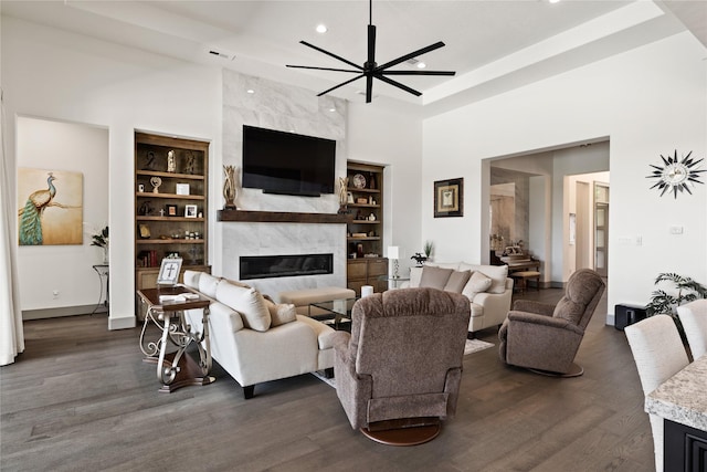 living area featuring recessed lighting, a high ceiling, built in shelves, and a high end fireplace