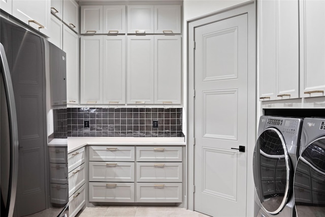 washroom featuring separate washer and dryer, cabinet space, and light tile patterned floors