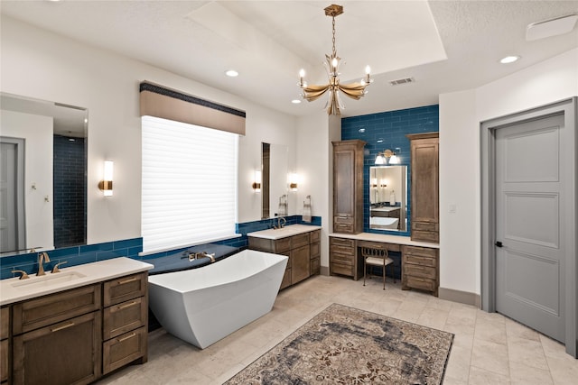 full bathroom featuring a soaking tub, a chandelier, two vanities, and a sink
