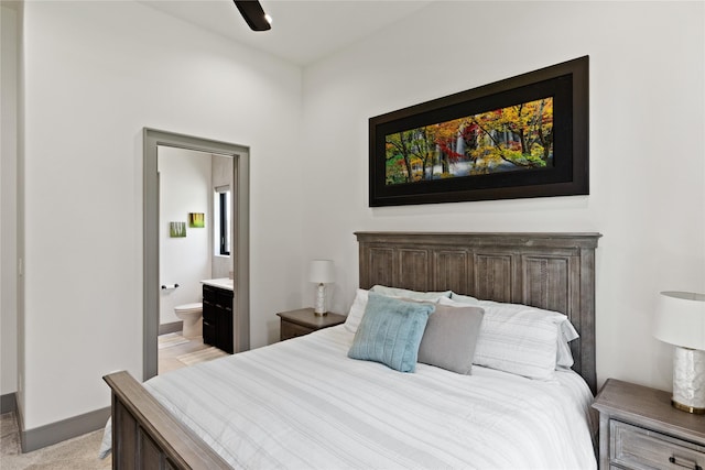 bedroom featuring baseboards and ensuite bath