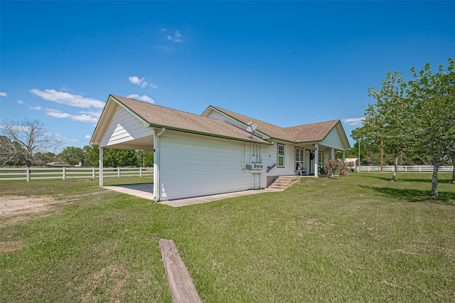view of side of property featuring a carport, covered porch, fence, a yard, and roof with shingles