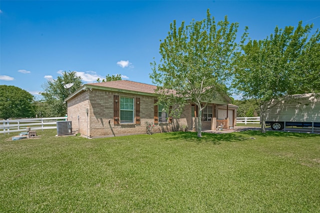 back of property featuring central AC, fence, and a lawn