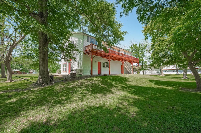 back of house with a wooden deck and a yard