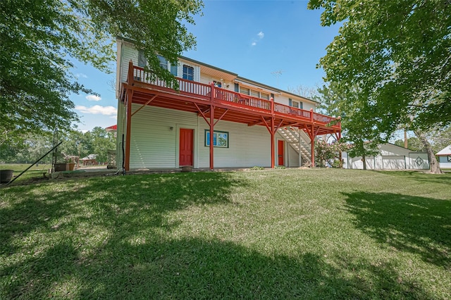 rear view of property featuring a wooden deck, a yard, and stairs