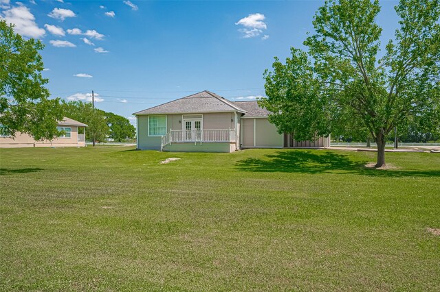 rear view of house featuring a yard and french doors