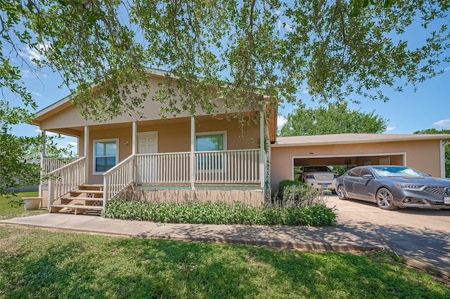view of front of home featuring stucco siding, covered porch, and concrete driveway