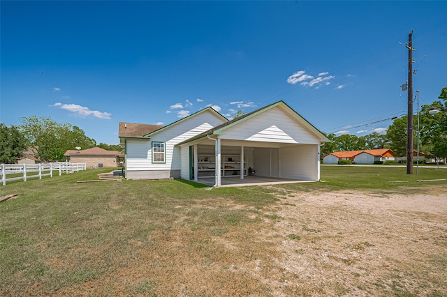 back of property featuring a lawn, fence, and a carport