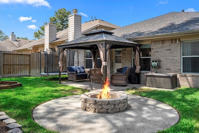 rear view of house with a gazebo, fence, a yard, a patio, and an outdoor living space with a fire pit