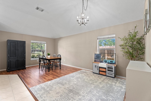 dining space featuring dark wood finished floors, visible vents, baseboards, and a notable chandelier