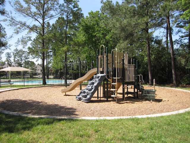 community jungle gym with a community pool and fence