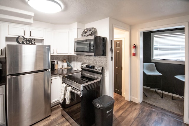 2817 Southmore Blvd, Houston, TX 77004 - kitchen featuring white cabinets, backsplash, stainless steel appliances, and dark wood-type flooring