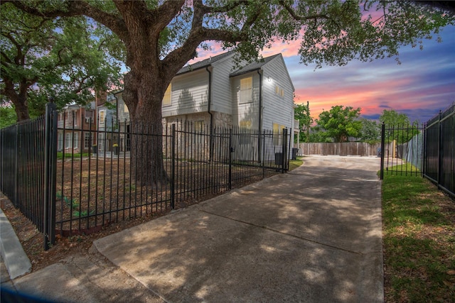 2817 Southmore Blvd, Houston, TX 77004 - property exterior at dusk with a fenced front yard and concrete driveway