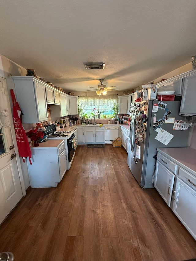 9341 Rosstown Way, Houston, TX 77080 - kitchen with gas range oven, dishwasher, freestanding refrigerator, dark wood finished floors, and a sink