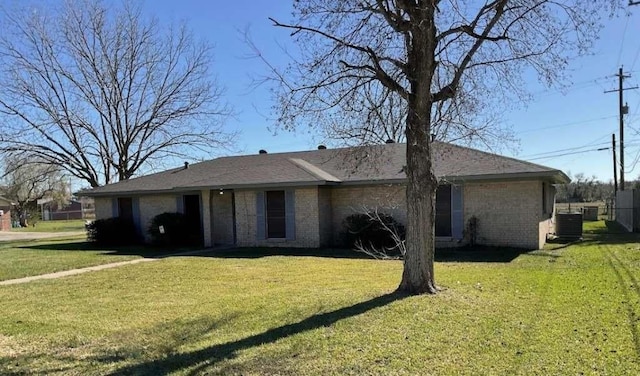 exterior space featuring a front lawn, brick siding, and cooling unit