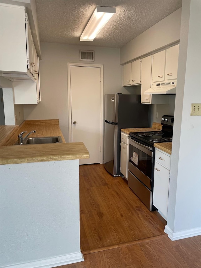 kitchen featuring dark wood-style floors, a sink, stainless steel electric range, visible vents, and under cabinet range hood