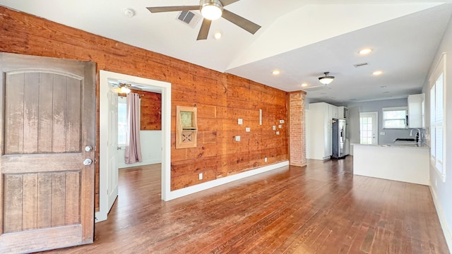 unfurnished living room with dark wood finished floors, visible vents, ceiling fan, and a sink