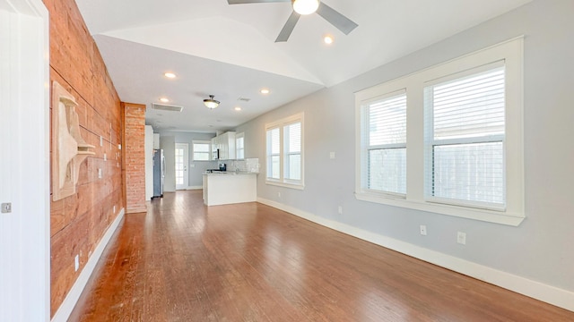 unfurnished living room featuring visible vents, baseboards, a ceiling fan, and dark wood-style floors