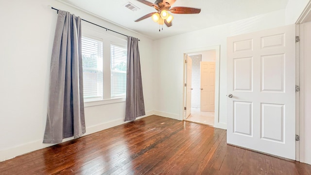 empty room featuring baseboards, a ceiling fan, hardwood / wood-style floors, and visible vents