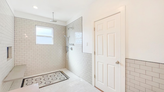 bathroom with tile walls, tile patterned floors, and tiled shower
