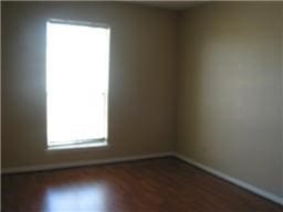 spare room featuring dark wood-type flooring and baseboards