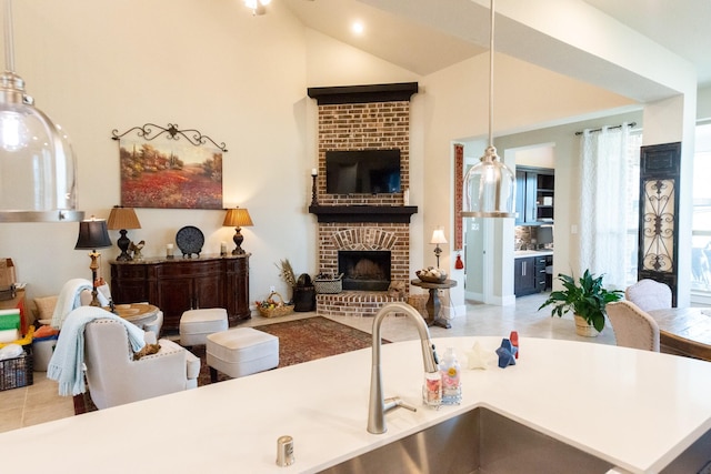 11903 Muir Groves Trl, Humble, TX 77346 - kitchen with vaulted ceiling, open floor plan, a brick fireplace, pendant lighting, and tile patterned floors