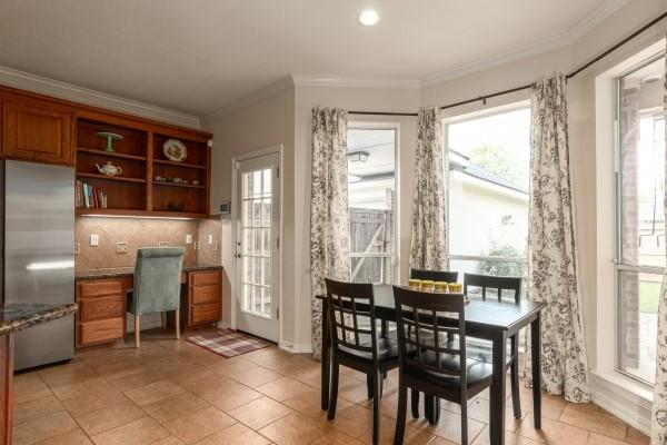 dining space featuring built in study area, ornamental molding, and light tile patterned floors