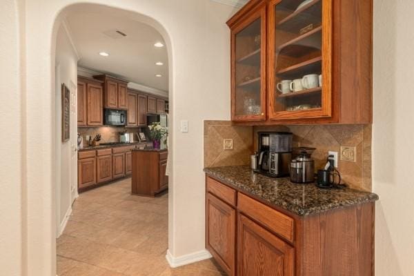 bar featuring arched walkways, tasteful backsplash, recessed lighting, crown molding, and black microwave