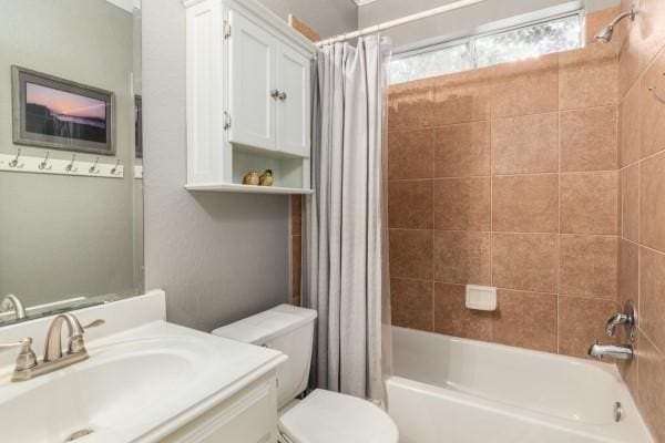 bathroom featuring shower / tub combo, toilet, and vanity