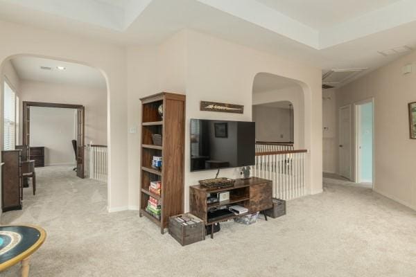 carpeted living room featuring arched walkways