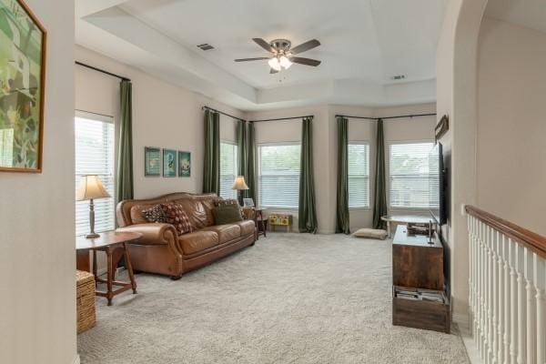 living room featuring arched walkways, a ceiling fan, and carpet floors