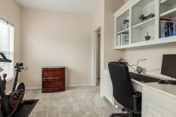 office with baseboards and light carpet