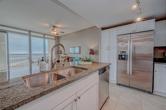 801 E Beach Dr Unit Tw1012, Galveston, TX 77550 - kitchen featuring stainless steel appliances, a sink, ceiling fan, and dark stone countertops