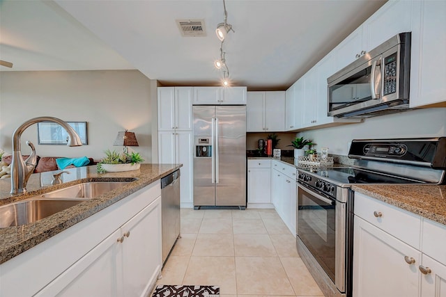 801 E Beach Dr Unit Tw1012, Galveston, TX 77550 - kitchen with appliances with stainless steel finishes, a sink, white cabinets, and stone counters