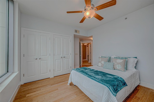 801 E Beach Dr Unit Tw1012, Galveston, TX 77550 - bedroom featuring two closets, light wood-style floors, baseboards, and ceiling fan