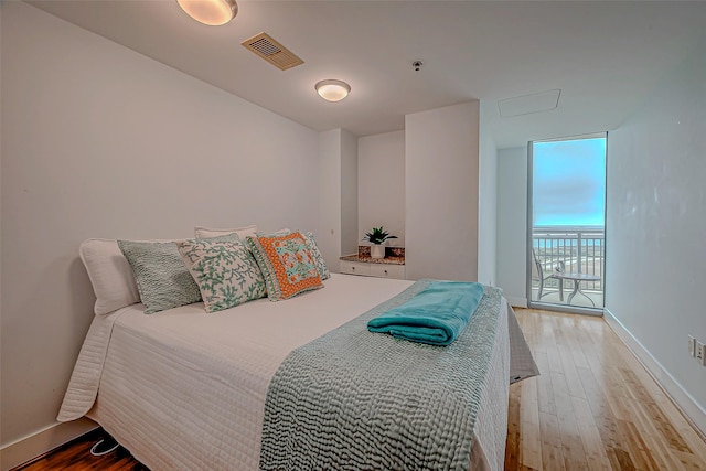 801 E Beach Dr Unit Tw1012, Galveston, TX 77550 - bedroom with wood finished floors, baseboards, and access to outside