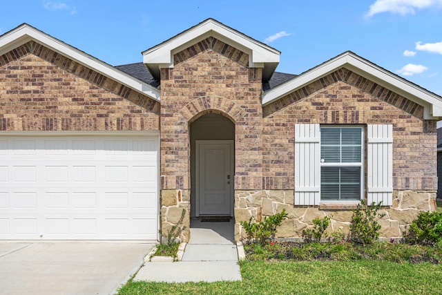 view of front of house with driveway, brick siding, and a garage